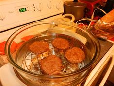 some food is cooking in a glass bowl on the stove top and it's ready to be cooked