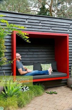 a man sitting on a bench in the middle of a garden