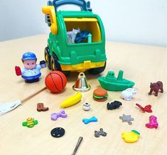 there are many toys on the table and one has a toy truck with it's door open