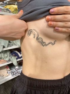 a woman's stomach with a tattoo on her lower back and the bottom part of her body