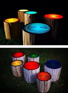 several different colored lights on wooden stumps in the grass