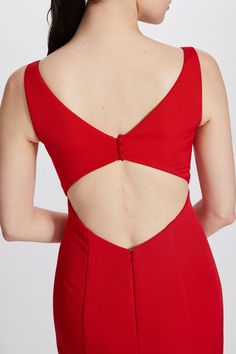 the back of a woman wearing a red dress with cut out shoulders and open sides