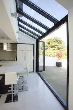 an open kitchen and dining room with glass walls