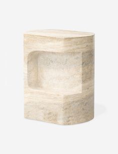 a white marble block with an open hole in the middle on a grey background,