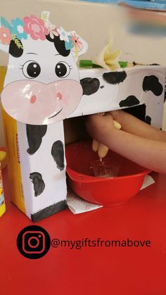 a paper cow statue sitting on top of a red table