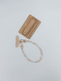 a wallet, necklace and card holder on a white surface