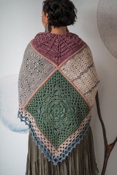 a woman wearing a crocheted shawl with an intricate design on the back