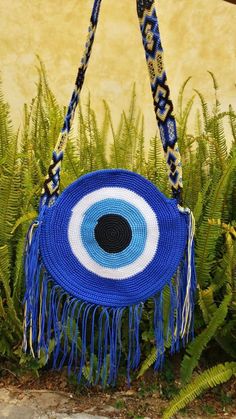 These beautiful, one-of-a-kind, 100% handmade crochet evil eye bags are made by artisans in Mexico. Each features a unique and one-of-a-kind strap! They also have a zipped to secure your belongings. Please choose the color of the bag in the drop down menu. You will receive a bag that is the color selected, however, the woven strap may vary in pattern and colors. They are all beautiful and colorful! Approximate dimensions: 35cm or 12.5in diameter These are handmade products and occasionally minor Handmade Blue Crochet Bag For Festival, Handmade Blue Crochet Bag As Gift, Handmade Bohemian Blue Crochet Bag, Handmade Blue Crochet Bag As A Gift, Handmade Blue Bohemian Crochet Bag, Handmade Blue Crochet Bag For Gift, Blue Handmade Bohemian Crochet Bag, Blue Bohemian Handmade Crochet Bag, Homemade Purses