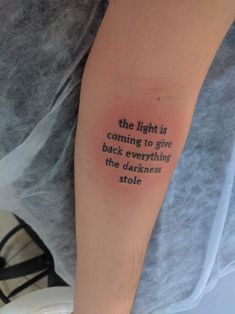 a person with a tattoo on their arm that says, the light is coming to give back everything the darknesss stole