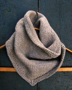 a gray scarf hanging on a wooden hanger