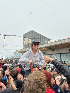 a woman riding on the back of a man in front of a crowd of people