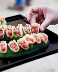 a person is picking up some food from a tray