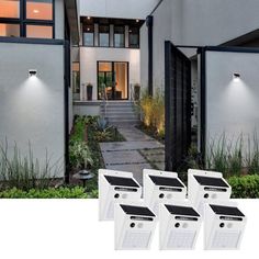 four solar powered motion sensor lights in front of a house