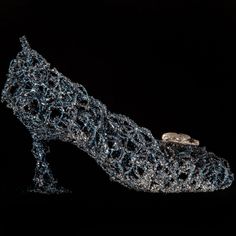 a pair of shoes that are made out of silver wire and glass beads on a black background