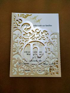 an ornate laser cut wedding card with the letter e on it