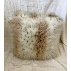 an animal fur pillow is laying on a bed