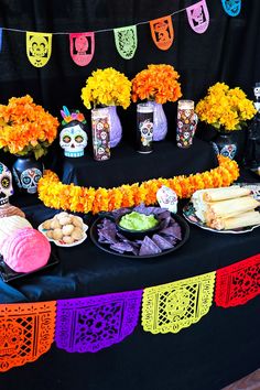 a table topped with lots of food and decorations on top of a black table cloth