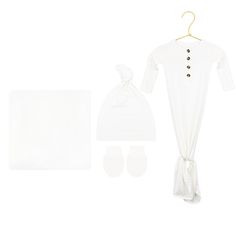 a baby's white outfit and bib with matching booties is displayed on a white background