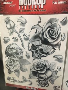 an advertisement for tattoos on display in a store front window, featuring roses and skulls