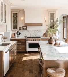 a kitchen with wooden floors and marble counter tops, along with an oven in the center