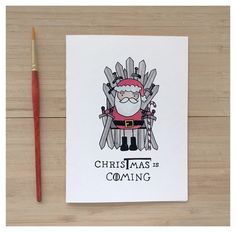 a christmas card with a santa clause sitting on the iron throne next to a pencil