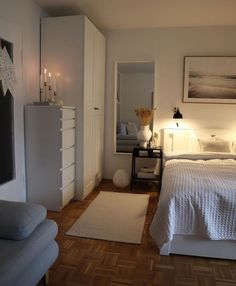 a bedroom with a white bed and wooden floors