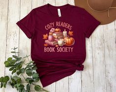 Cozy Readers Book Shirt,Pumpkin Patch Shirt,Fall Clothing,Vintage Tee,Autumn Shirt,First Day Of Fall Shirt,Pumpkin Sweatshirt,Fall Apparel My shirts, sweatshirts, and tanks are a fun and joyous way to show your style while shopping, heading to the beach, and bringing your children to social events, family outings, and everyday life. All my t-shirt designs are direct to garment and provide the best quality and longevity.  Cozy Readers Book Society Picture: Writing, Books and Pumpkins Sizes: XS-2X Fall Bookish Tops With Graphic Print, Fall Graphic Print Bookish Tops, Comfortable Slogan T-shirt For Fall, Fall Book Shirt, Bookish Fall T-shirt With Letter Print, Fall Bookish T-shirt With Letter Print, Fall Slogan T-shirt Relaxed Fit, Fall Fan Merchandise Long Sleeve T-shirt, Patches Shirt