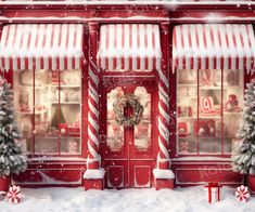 a red store front with christmas decorations on the windows and snow covered trees in front