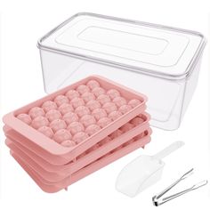 the container is filled with plastic balls and spoons next to it are utensils