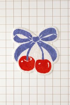 a blue and white rug with two cherries on it, tied in a bow