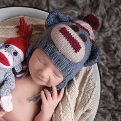 a baby is wearing a sock hat and holding a stuffed animal