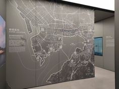 a large map is on display in a room with gray walls and white flooring