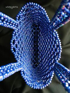 blue beads are arranged in the shape of a spiral on a black cloth with text overlay that reads, how to make beaded bracelets