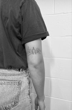 the back of a man's left arm with two birds on it, tattoo