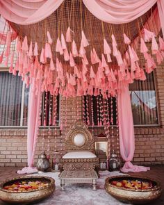 a decorated stage with pink drapes and tassels hanging from it's ceiling