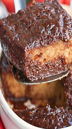 a close up of a spoon in a bowl of food with chocolate sauce on it