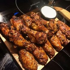 some chicken wings are sitting on a cutting board