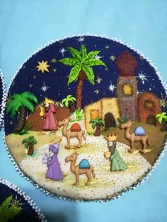 the nativity scene is depicted in this handmade ornament, which includes camels and palm trees