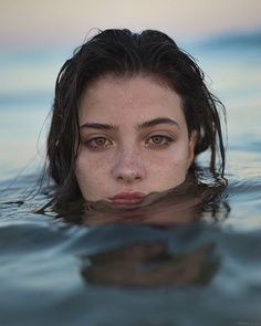 a woman swimming in the water with her eyes closed