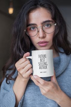 a woman wearing glasses holding a coffee mug with the words smile more written on it