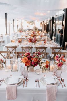 a table set with flowers and candles for a wedding reception