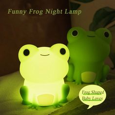 two green frog lamps sitting on top of a bed with a speech bubble saying funny frog night lamp