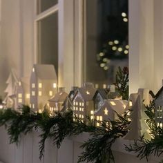 a window sill decorated with christmas lights and greenery