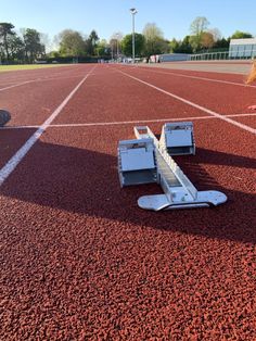 an empty tennis court with some equipment on the ground