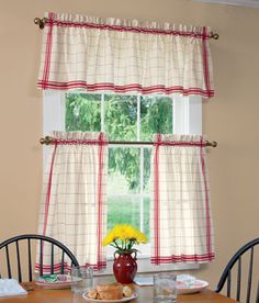 a dining room table and chairs in front of a window with the curtains pulled back