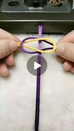 someone is making something out of yarn and string with scissors on the end, while another person holds it in their hands