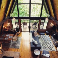 an aerial view of a living room and dining area in a cabin with wood flooring