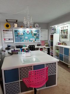 a room with a desk, chair and shelves filled with crafting supplies on it