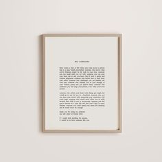 a framed print with an old fashioned typewriter's handwriting on it, in front of a white wall