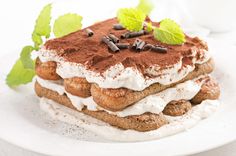 three layered desserts are stacked on top of each other with mint sprigs